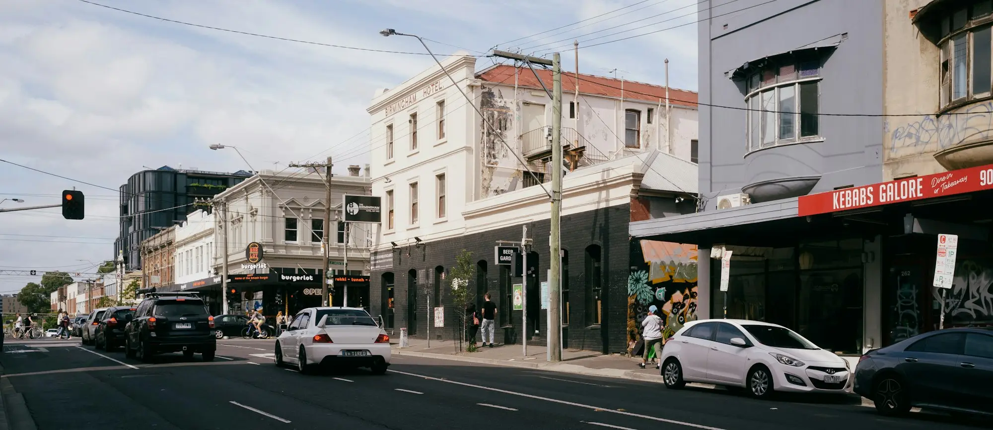 Street of small commercial buildings with parked cars