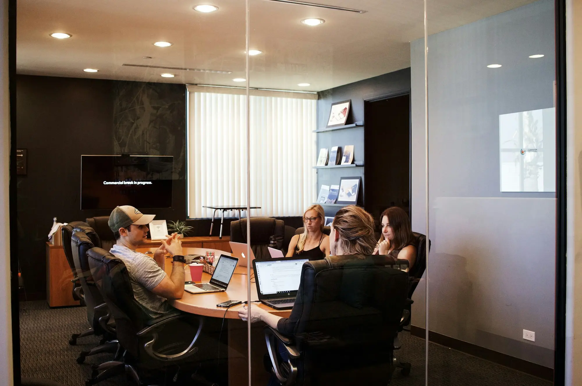 Company directors meeting around a table with a laptop and notes